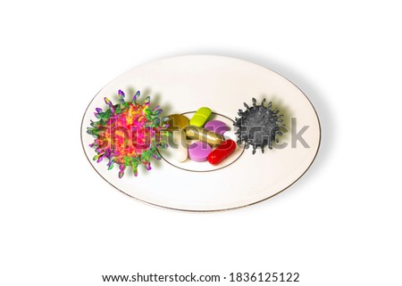 Concept of searching for drugs against coronavirus: ceramic plate with colourful pills with alive or dead COVID 19 species on white background
