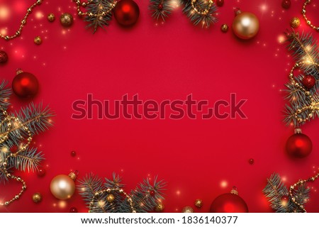 Red Christmas background. Frame of fir tree, garland lights, gold Christmas decorations. Copy space, flat lay.