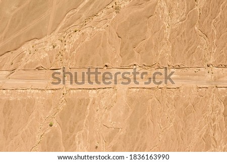 Desert landscape with dirt path crossing, Aerial image.