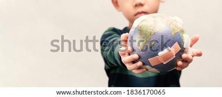 Closeup banner of cute little asian boy as a new generation holding and show damage globe full of bandages. Net zero 2050, Climate change, Environmental problems. World pollution, Pandemic, Earth Day Royalty-Free Stock Photo #1836170065