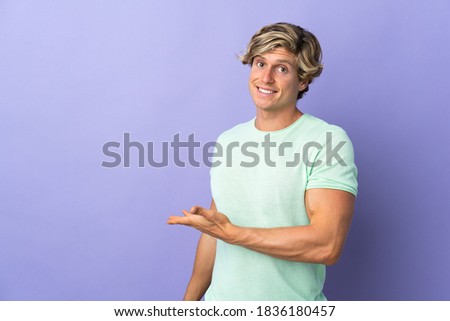 English man over isolated purple background presenting an idea while looking smiling towards