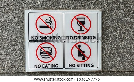 Many prohibition signs on a walll. No smoking, no drinking, no eating, no sitting
