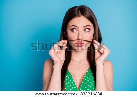 Closeup photo of attractive funny lady play curl make fake mustache pretend guy behavior send air kisses look side empty space wear green summer top tank-top isolated blue color background