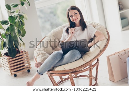 Photo of minded girl sit chair use laptop for buying purchase hold credit bank think in house indoors