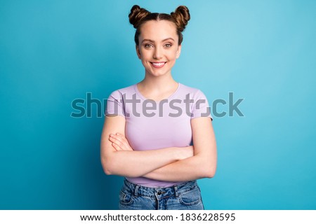 Photo of attractive teen lady two funny buns good mood toothy white smile charming nice person business freelancer arms crossed wear casual purple t-shirt isolated blue color background