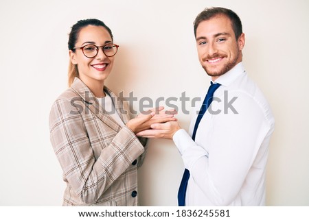 Beautiful couple wearing business clothes pointing aside with hands open palms showing copy space, presenting advertisement smiling excited happy 