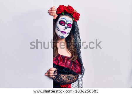 Young woman wearing day of the dead custome holding blank empty banner with a happy and cool smile on face. lucky person. 