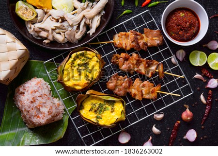 Nam Prik Ta Dang and Sticky Rice, Grilled Pork, Eggs Wrapped with Banana Leaf, and Boiled Vegetables that are eaten together, food in northern Thailand.