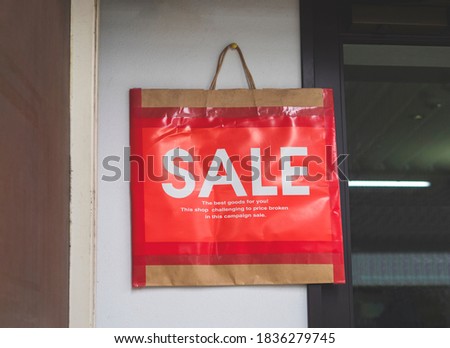 Sale sign on paper bag hanging on the shop wall , bargain campaign concept