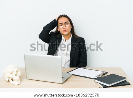 Young traumatologist asian woman isolated on white background tired and very sleepy keeping hand on head.