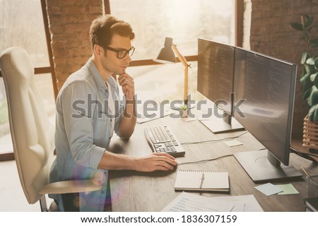 Profile side view portrait of his he nice attractive focused professional guy coding programming supporting web site remotely at modern industrial interior loft brick style work place station