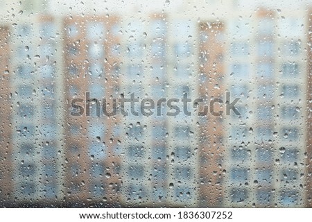 Rain drops on window glass with house in background