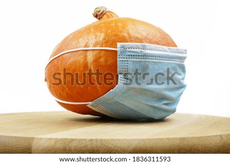 pumpkin wearing a face mask for protection from coronavirus. Halloween 2020 concept, closeup
