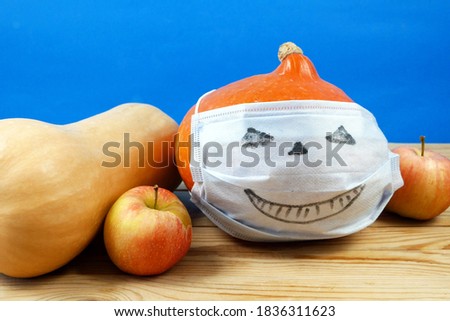 pumpkin wearing a face mask for protection from coronavirus witth halloween face. Halloween 2020 concept, closeup