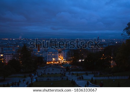 Paris night view from Montmartre hill. Beautiful evening blue hour cityscape with street lights background. France winter travel tourism.  Selective focus.