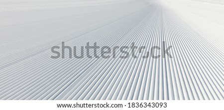 Close-up straight line rows of freshly prepared groomed ski slope piste. Royalty-Free Stock Photo #1836343093