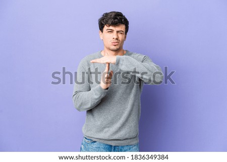 Young cool man showing a timeout gesture.