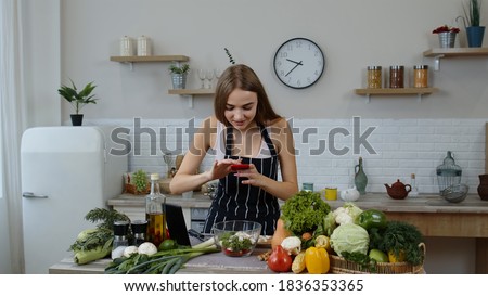 Girl making photos for social media on smartphone at kitchen. Young blogger woman preparing food, taking pictures on phone for her social accounts or video stories. Weight loss and diet