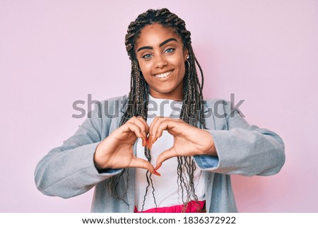 Young african american woman with braids wearing business jacket smiling in love showing heart symbol and shape with hands. romantic concept. 