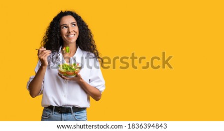 Cheerful Woman Eating Vegetable Salad From Bowl And Looking At Copy Space On Yellow Background, YoungLady Enjoying Heathy Nutrition And Organic Food, Having Vegetarian Meal For Lunch, Panorama Royalty-Free Stock Photo #1836394843