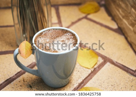 Morning coffee in blue cup and autumn interior