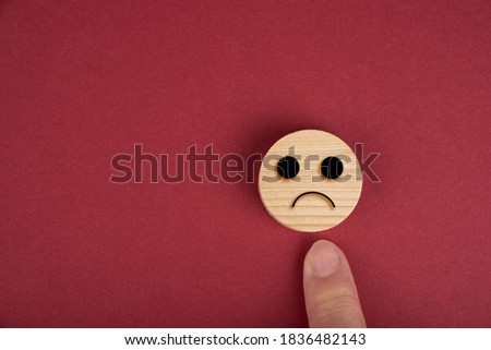 Sad smiles on a wood circles on wood on a red