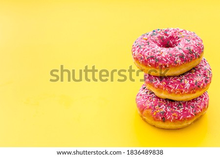 Pink berry donuts close up. Glazed and sprinkles bakery