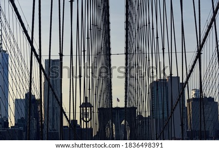 ymmetry of Brooklyn Bridge pillars and skyscraper buildings in the evening. Stage photo. USA. New York.