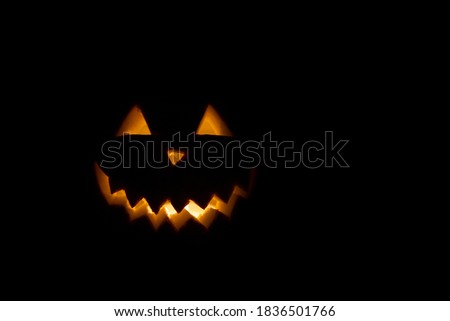 Halloween pumpkin in the dark with lighted candle inside. horror theme and Hallowe'en.