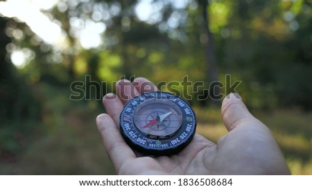 close up a male tourist holds glass compass in his hands while in the forest