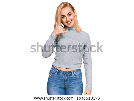Beautiful caucasian woman wearing casual clothes smiling doing phone gesture with hand and fingers like talking on the telephone. communicating concepts. 