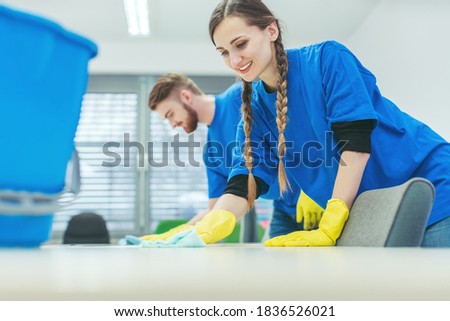 Cleaning crew wiping desks in an office building Royalty-Free Stock Photo #1836526021