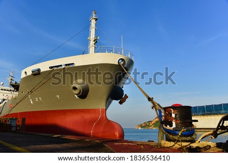 Front tanker ship moored alongside in shipyard and anchor rope line