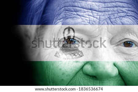 Portrait of older lady with painted national flag of Lesotho