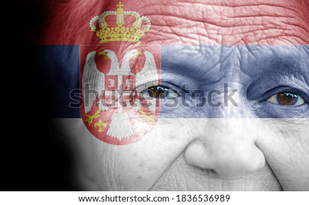 Portrait of older lady with painted national flag of Serbia