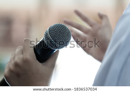 Smart businessman speaker speech with microphone at seminar conference and speaking with mic in auditorium room while explaining or gesturing in event light convention hall Background