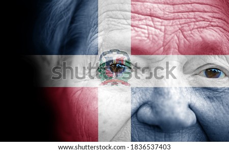 Portrait of older lady with painted national flag of Dominican Republic