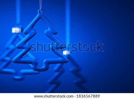 Three glass Christmas balls. Tree contour shape baubles hanging against royal blue background. Christmas decoration, festive atmosphere concept. Selective focus, copy space.