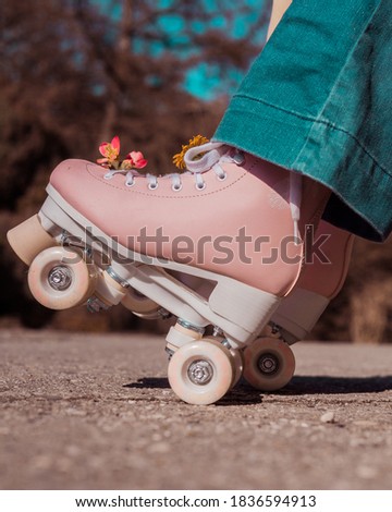 Pink roller skates and blue jeans in vintage mood.