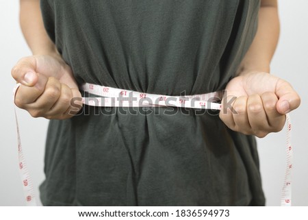 Picture of belly fat and waist measurement tape.