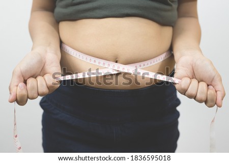 Picture of belly fat and waist measurement tape.
