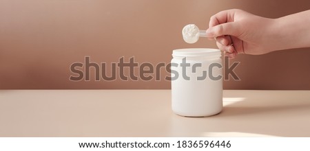 hand holding scoop of fish collagen. collagen peptides in container or jar. powder for mixing drink. Healthcare supplement concept. collagen for skin and joints .banner size. copy space Royalty-Free Stock Photo #1836596446