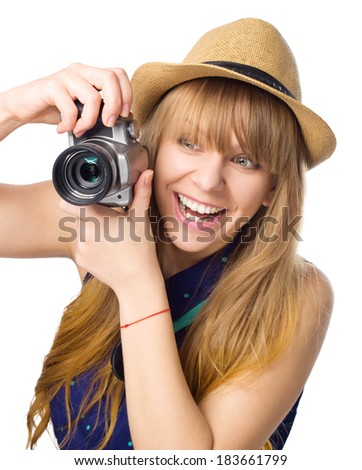 Expressive portrait of happy young girl holding camera, isolated over white
