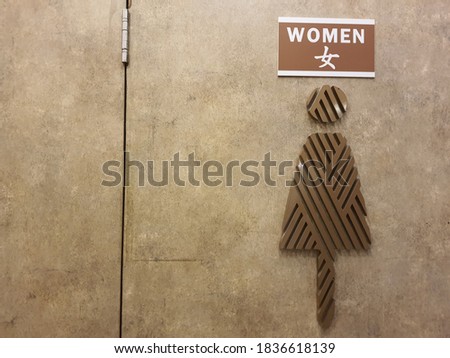 A sign of women restroom at concrete wall, selective focus