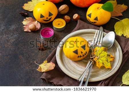 Halloween wooden table setting with pumpkins and tangerines. Copy space.