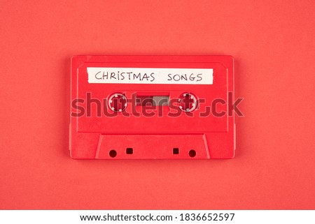 Audio cassette tape with christmas songs on a red background Royalty-Free Stock Photo #1836652597
