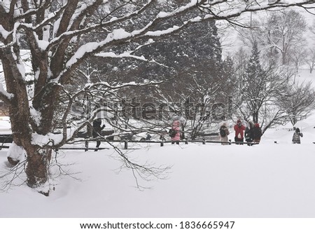 Tourists walking on Bridge over river while snowing winter to Shirakawago villages. Japan