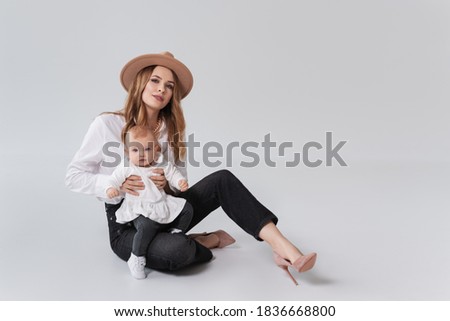 Happy family concept. Mother holding cute baby isolated on grey  background. . Motherhood and children concept. Close up, copy space