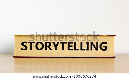 Book with text 'storytelling' on beautiful wooden table, white background. Business concept. Copy space.