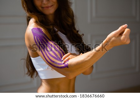 Kinesio taping, kinesiology. Girl with kinesio tape, muscle tape on the shoulder